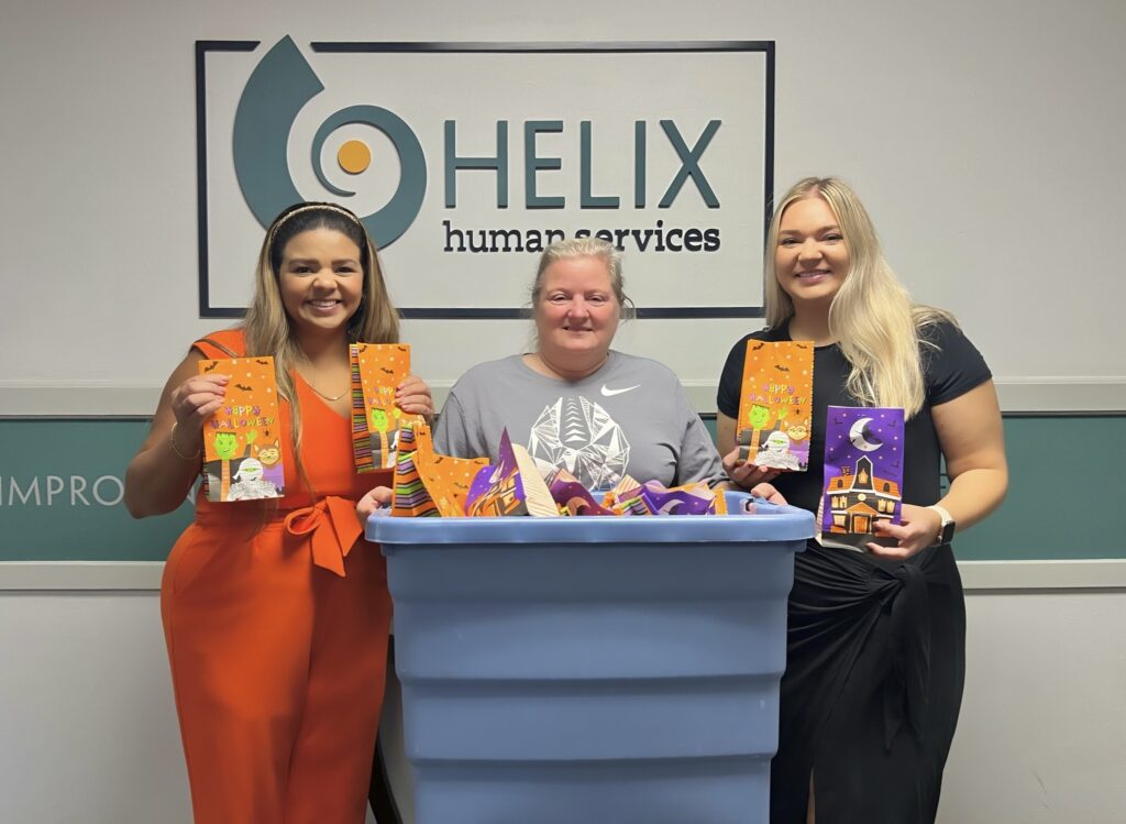 Pictured is Helix Human Services Chief Relations Officer Yamilca Nogué, Agawam Junior Women's Club member Lynn, and Helix Human Services Marketing and Development Coordinator Emily with a Halloween donation.